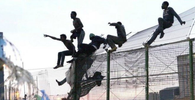 Varios migrantes tratan de saltar la valla fronteriza entre Melilla y Marruecos.- EFE/ARCHIVO