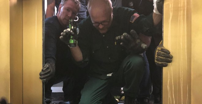 El equipo de rescate abre la puerta del ascensor donde quedaron atrapadas seis personas en Chicago. /REUTERS