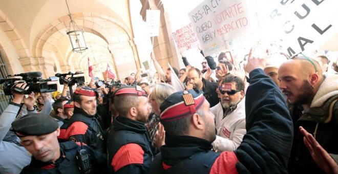 Mossos d'Esquadra tratan de impedir que los médicos de atención primaria que se concentran ante el Parlament, convocados por Médicos de Cataluña (MC), en la tercera jornada de huelga para exigir mejoras asistenciales y laborales en el sistema de salud, en