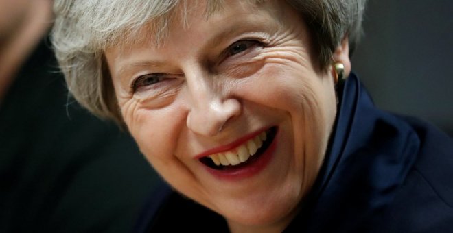 La primera ministra británica, Theresa May, reacciona durante su visita al Scottish Leather Group Limited en Bridge of Weir en Escocia el 28 de noviembre de 2018 | AFP