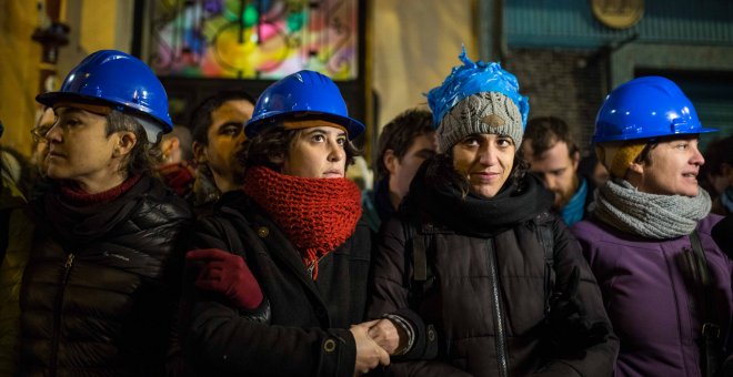 Un grupo de activistas hace un cordón humano frente a la Policía, en la puerta del edificio del número 11 de la calle Argumosa, en Madrid, para evitar que se ejecute el desahucio de Pepi Santiago.- JAIRO VARGAS