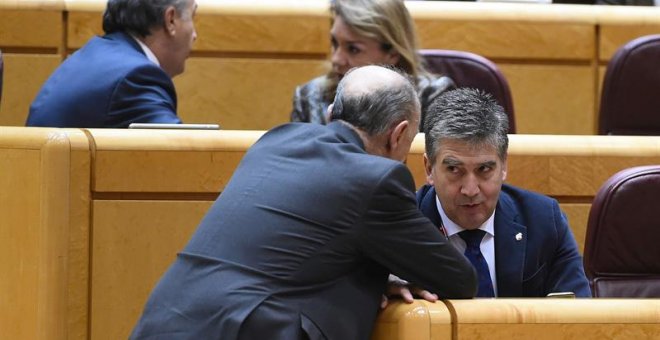 El portavoz del PP en el Senado, Ignacio Cosidó (d), conversa con un compañero durante el Pleno del Senado donde tiene lugar una votación sobre la proposición de ley orgánica de reforma de la ley del Poder Judicial sobre medidas urgentes en aplicación del