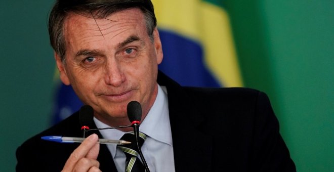 El presidente de Brasil, Jair Bolsonaro, durante la firma del decreto que facilita la compra de armas en el país. / REUTERS - UESLEI MARCELINO