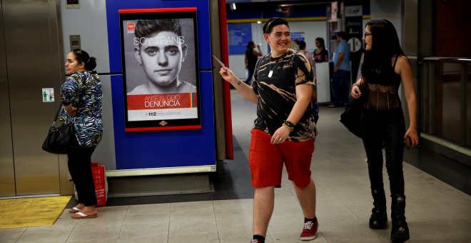 Gabriel Díaz de Tudanca le enseña a una amiga la campaña de concienciación en la que participó para el Ayuntamiento de Madrid. / REUTERS - SUSANA VERA