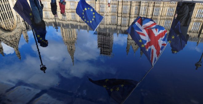 Banderas del Reino Unido y de la UE, reflejadas en un charco de agua frente al Parlamento británico, en Westminster, en una manifestación conraria al brexit. REUTERS/Toby Melville