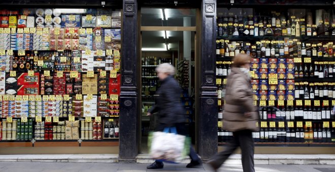 Varias personas pasan por delante de una tienda de alimentación en el centro de Barcelona. REUTERS/Albert Gea