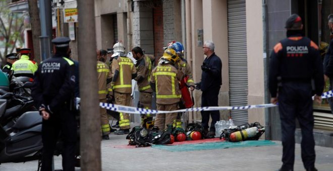 Bomberos y Mossos d'Esquadra permanecen en las inmediaciones del inmueble situado en la calle Riera Blanca de L'Hospitalet de Llobregat (Barcelona) donde esta mañana se ha declarado un incendio en el que un adulto y un menor han muerto y otro menor ha res