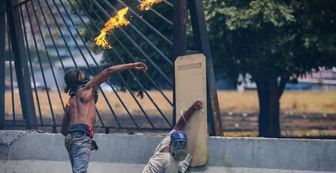 Opositores se enfrentan con la policía en una manifestación este miércoles en las calles de Caracas (Venezuela). /EFE