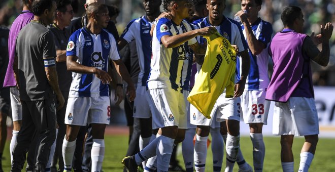 Momento en el que los jugadores celebran el gol con la camiseta del portero español. / AFP