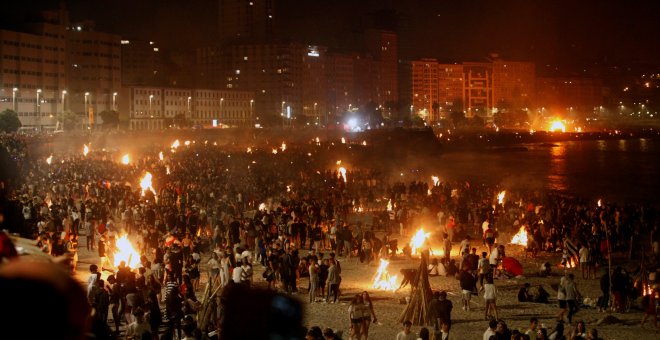 Miles de personan se reunieron en torno a las hogueras que iluminaron este domingo las playas en la noche mágica de San Juan | EFE