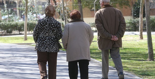 Pensionistas paseando por un parque.