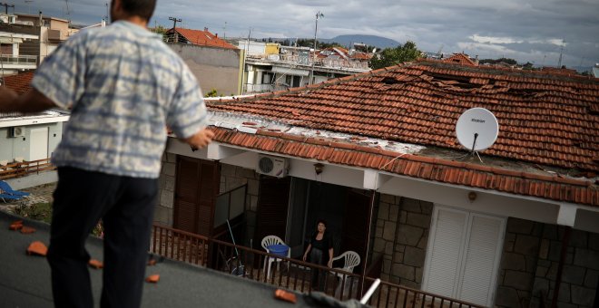 Una mujer en el balcón de su casa dañada después de fuertes tormentas en el pueblo de Nea Plagia, Grecia, el 11 de julio de 2019. REUTERS / Alkis Konstantinidis