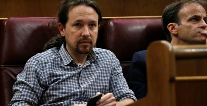 El líder de Unidas Podemos, Pablo Iglesias (izda), en su escaño del hemiciclo del Congreso