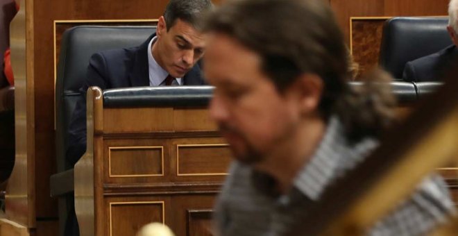 Pablo Iglesias, de camino a la tribuna del Congreso mientras Pedro Sánchez toma unas notas. (J.J. GUILLÉN | EFE)