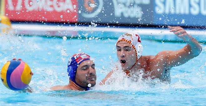 Munárriz (derecha) le disputa el balón a Buslje en la semifinal del Mundial de Waterpolo. / EFE