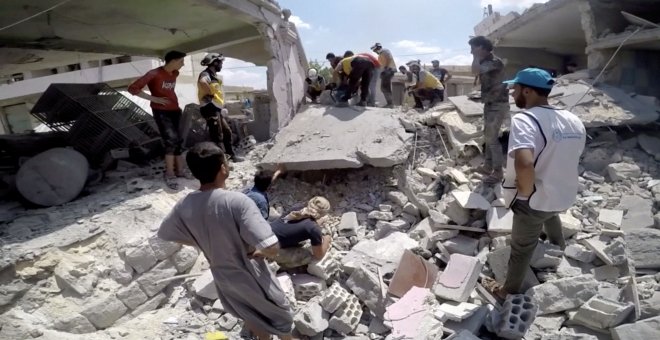 Un miembro de White Helmets usa una sierra en los escombros después de un ataque aéreo en esta captura de pantalla tomada de un vídeo de redes sociales | Reuters