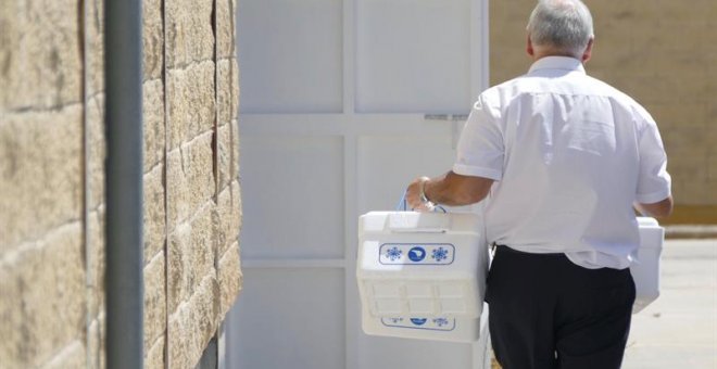 27/08/2019.- Un operario del Ayuntamiento de Sevilla llega con unas neveras para recoger muestras en la sede de la empresa Magrudis que fabricaba la carne mechada origen del brote de listeriosis, y donde se encuentran los dueños y los abogados de la famil