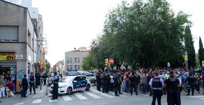 Mossos d'Esquadra controlan a la multitud que se ha congregado ante el domicilio en el que agentes de la Guardia Civil llevan a cabo un registro en Sabadell (Barcelona). /EFE