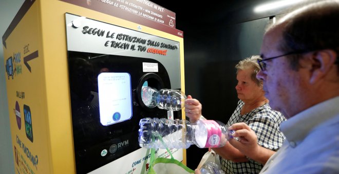 Dos vecinos de Roma haciendo uso de esta iniciativa que une reciclaje y transporte público. / Reuters