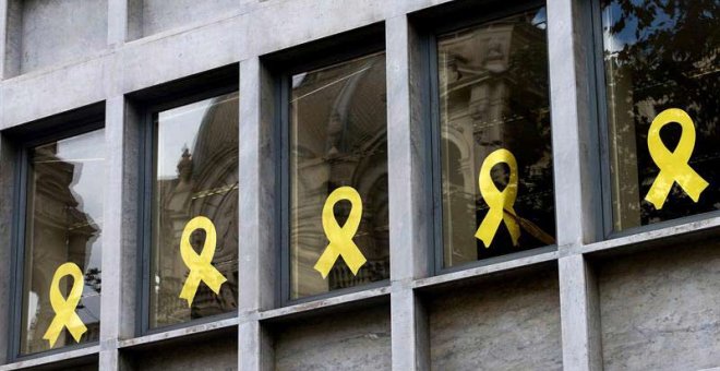 Trabajadores del Departamento de Agricultura Ganadería ,Pesca y Alimentación de la Generalitat retiran lazos de las ventanas del edificio de la consellería. (QUIQUE GARCÍA | EFE)