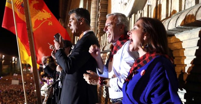 El alcalde de Zaragoza, Jorge Azcón; la vicealcaldesa de la ciudad, Sara Fernández, y los pregoneros de las fiestas del Pilar, el grupo de canto a Capella B vocal, en el balcón del ayuntamiento durante el pregón de inicio de fiestas. EFE/Javier Cebollada