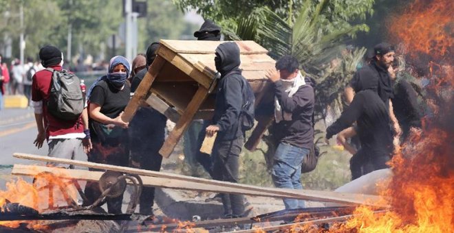 Manifestantes queman objetos durante una protesta contra el incremento del precio en los billetes del metro, este sábado en Santiago (Chile). Durante la semana, las protestas por el incremento del precio del billete del metro de Santiago de Chile fueron e