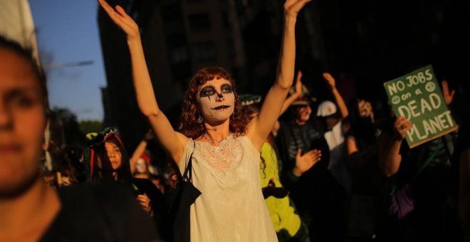 Manifestantes disfrazados participan en una protesta de Extinction Rebellion. EFE