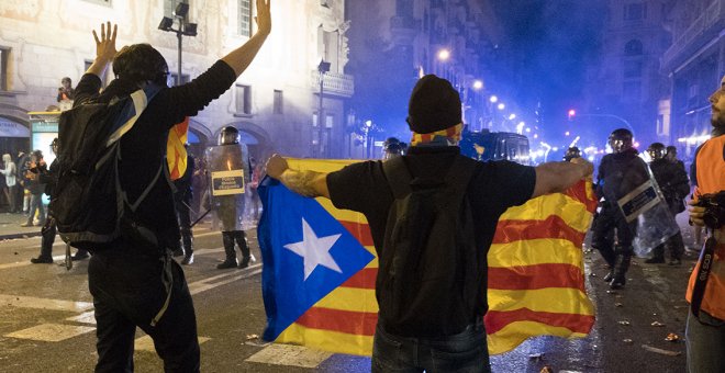 Dos jóvenes manifestantes se plantan frente a los antidisturbios de los Mossos en la Vía Layetana, junto a Urquinaona. GUILLEM SANS