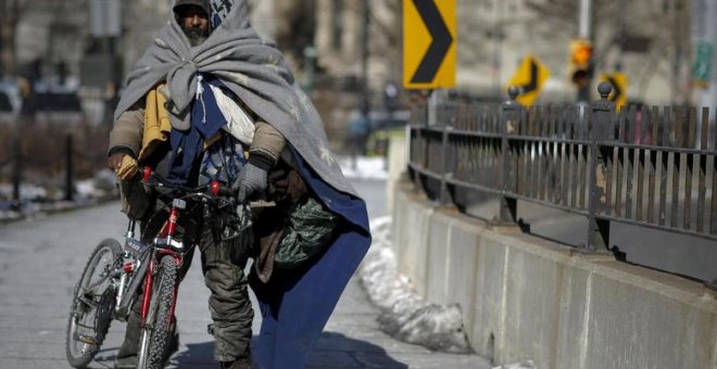 Un ciudadano de Nueva York sin hogar caminando por el puente de Brooklyn. / Reuters