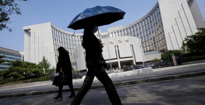 Varias personas pasan por delante de la sede del Banco Popular de China, el banco central, en Pekín. REUTERS/Jason Lee