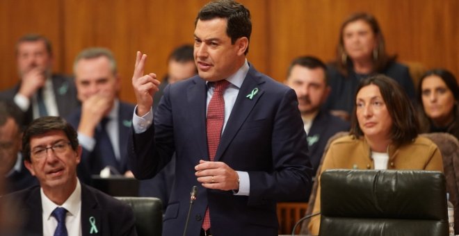 Juan Marín, sentado, y Juanma Moreno, de pie, con los lazos con la bandera de Andalucía en la solapa. Europa Press