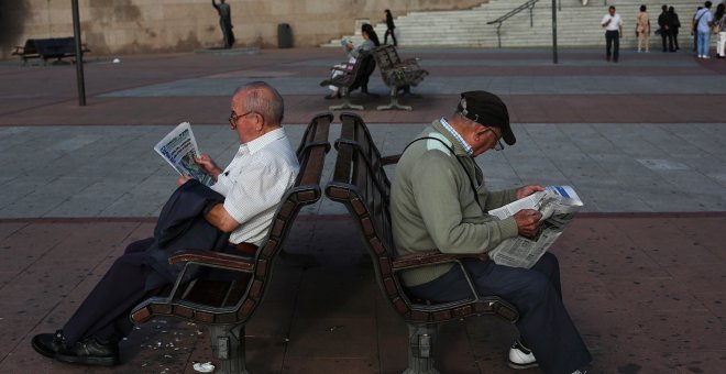 Unos pensionistas leen el periódico sentadados en un banco, en Madrid. REUTERS / Susana Vera