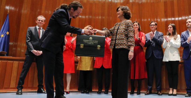 El líder de Podemos y nuevo vicepresidente de Derechos Sociales, Pablo Iglesias, hace una pequeña reverencia al recibir la cartera de manos de la vicepresidenta Carmen Calvo, en el acto de toma de posesión. REUTERS/Susana Vera