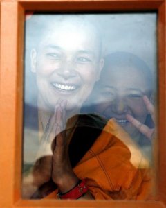 Dos monjas saludan a través de una ventana en el templo Naro Photang de la ciudad de Shey. - AFP