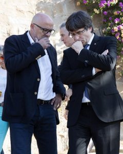 El presidente de la Generalitat, Carles Puigdemont (d), conversa con el presidente del grupo parlamentario de Junts pel Sí (JxSí), Lluís Corominas, tras la tradicional ofrenda ante la tumba del presidente de la Generalitat republicana Lluís Companys coinc