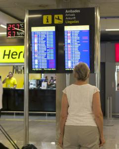 Una turista comprueba el estado de un vuelo en una pantalla del aeropuerto de Palma de Mallorca, en una jornada de huelga de controladores aéreos. EFE/MONTSERRAT T DIEZ