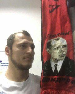 Roman Zozulya posa junto a una bufanda de Stepán Bandera.