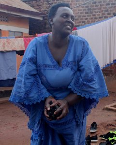 Una madre ugandesa recogiendo carbón vegetal para preparar el almuerzo en el barrio de Makerere Kikoni. - PABLO L. OROSA