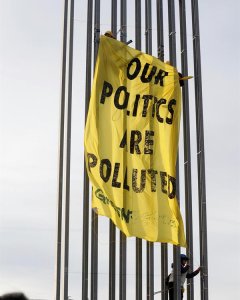 Varios activistas de Greenpeace despliegan una pancarta en una torre de iluminación del recinto ferial IFEMA, en la jornada final de la Cumbre del Clima COP25, este viernes, en Madrid. Los activistas protestan contra la 'mercantilización de las negociacio