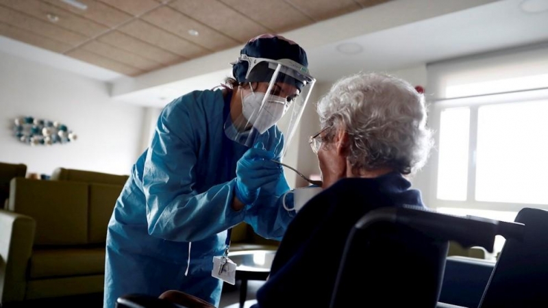 Una cuidadora ayuda a comer a una anciana en una residencia madrileña. EFE/Mariscal