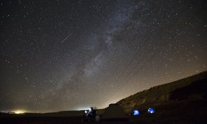 Los meteoros cruzan en el cielo mientras un hombre los observa durante la lluvia de estrellas cerca del pueblo de Mitzpe Ramon, al sur de Israel.- REUTERS / Amir Cohen