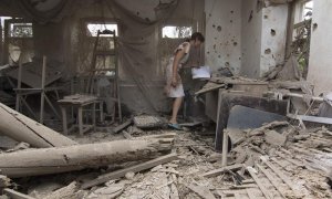 Una mujer revisa los restos de una casa tras un bombardeo en la localidad bajo control ucraniano de Sartana, cerca de la ciudad oriental de Mariupol (Ucrania) hoy, 17 de agosto de 2015. EFE/Sergey Vaganov