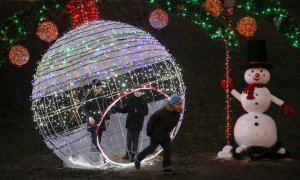 Varios niños juegan en un parque que está decorado con luces de navidad, en Kiev, Ucrania. REUTERS / Valentyn Ogirenko