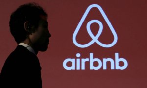 La sombra de una persona frente al logotipo de AirBnB. EFE