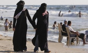 Dos mujeres con velo islámico en una playa.