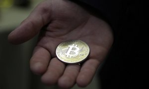 Un hombre enseña una moneda representativa de Bitcoin, en Moscú (Rusia).. EFE/Maxim Shipenkov