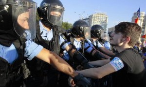 Un manifestante se encara con la policía durante las protestas en Bucarest | EFE