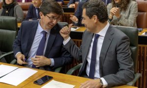 06/02/2019.- El presidente andaluz, Juanma Moreno, y el vicepresidente, Juan Marín (i), conversan en sus escaños durante el pleno del Parlamento de Andalucía esta tarde en Sevilla, que ha elegido, en la primera sesión plenaria de la XI Legislatura, a los