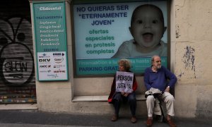 Un hombre y una mujer descansan tras participar en una manifestación reclamando pensiones justas. REUTERS/Susana Vera