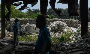 Voluntarios de una(ONG) se encuentran cerca de los desechos plásticos en una fábrica abandonada en Jenjarom, un distrito de Kuala Langat, en las afueras de Kuala Lumpur. MOHD RASFAN / AFP